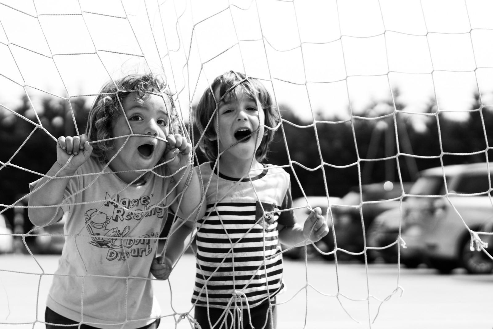 Two children playing at goal net